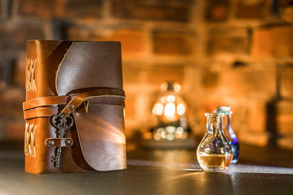 Leather journal and vintage key setup with potion bottles, perfect for magical or fantasy themes.