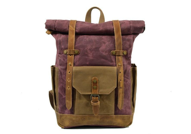 A handmade canvas backpack with waxed canvas and full grain leather, featuring multiple pockets and a shoulder strap.